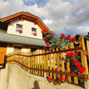 塔尔维西奥Al sentiero di Charly的一座房子,上面有红色花卉围栏