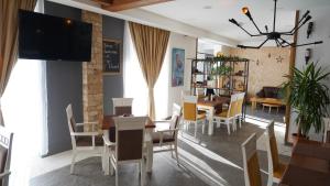 莫伊科瓦茨Hotel Serdar的一间带桌椅和电视的用餐室