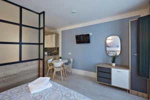 洛格罗尼奥Apartamentos Abastos的一间拥有蓝色墙壁的卧室和一张带镜子的桌子