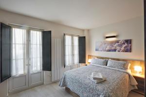 洛格罗尼奥Apartamentos Abastos的一间卧室配有一张带蓝色毯子的床和窗户。