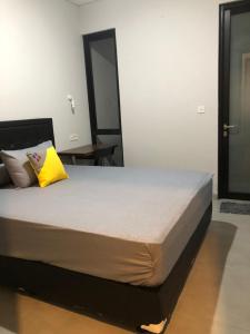 雅加达Cozy Puri的一间卧室配有一张黄色枕头的床