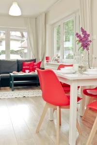 扎科帕内Apartament Giencyno Koncina Zakopane的客厅配有白色桌子和红色椅子