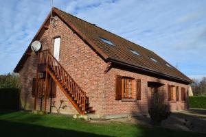 梅利蒙Les chambres d hôtes de l entre deux baies à Merlimont entre Berck et le Touquet的一座小砖房子,上面有楼梯