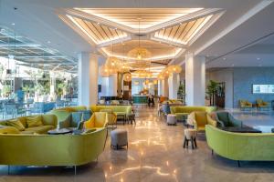埃拉特Vert Hotel Eilat by AFI Hotels的酒店大堂设有黄色的沙发和椅子