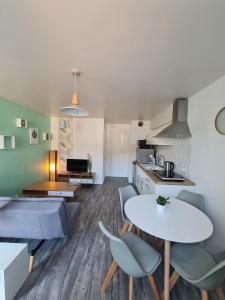 永河畔拉罗什Gîte "Côté Terre", avec piscine chauffée的厨房以及带桌椅的起居室。