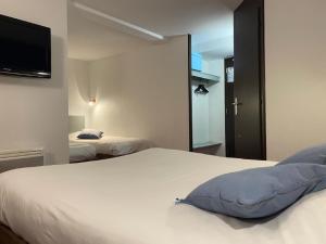 维耶尔宗Enzo Hotels Vierzon by Kyriad Direct的一间卧室设有两张床,墙上配有电视。