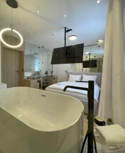 帕莱ConnectIN Apartments的一间位于床边的带浴缸的浴室