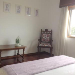 加亚新城myninho的一间卧室配有一张床、一把椅子和一张桌子