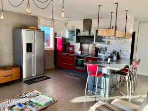 圣雷米普罗旺斯Terrasse sur les Alpilles的厨房配有不锈钢冰箱和红色橱柜