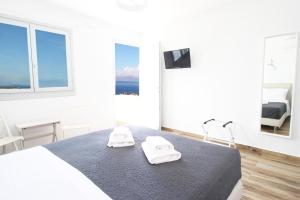 米克诺斯城Crystal View Mykonos的白色卧室配有带2条毛巾的床