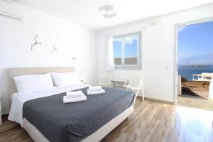 米克诺斯城Crystal View Mykonos的一间白色的卧室,配有一张床,享有海景