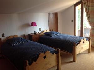 雷加霍斯达哈施Les Grangettes 2 - DUPLEX - WIFI gratuite的一间卧室设有两张床和窗户。
