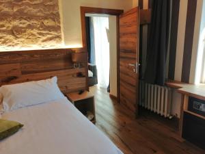 法纳诺佛罗伦萨酒店的卧室配有白色的床和木墙