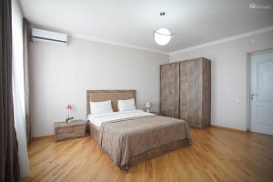 西格纳吉Zurabashvili Guest House的一间卧室设有一张大床,铺有木地板