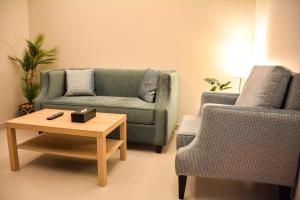 吉达Park Town的客厅配有沙发、桌子和两把椅子