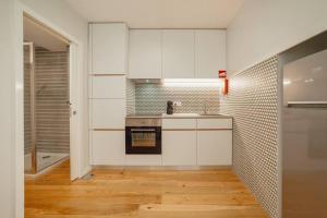 波尔图River Eyes Apartments的厨房配有白色橱柜和炉灶烤箱。