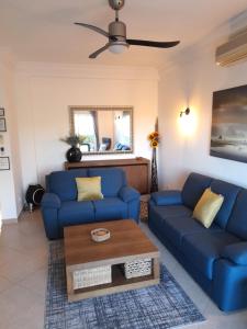 拉戈斯Fairviews Villa on Boavista Golf Resort的客厅配有蓝色的沙发和咖啡桌
