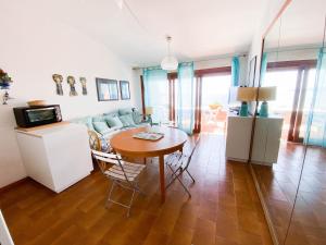 蒙泰亚尔真塔廖Porto S.Stefano CalaPiccola的厨房以及带桌子和沙发的客厅。