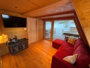 卡瓦莱塞Chalet Biancaneve - Alpe Cermis Cavalese的客厅配有红色沙发和平面电视