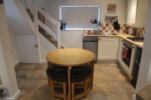 Cinderford孔雀度假屋的一个带桌子和楼梯的小厨房