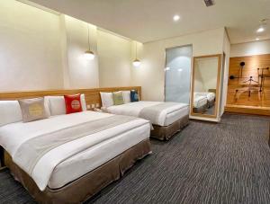 嘉义市天成文旅绘日之丘的酒店客房,设有两张床和镜子