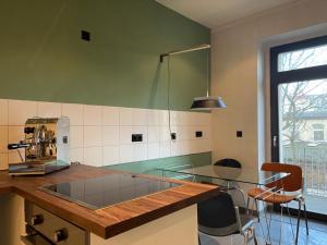 莱比锡Stilvoller Altbau mit Balkon - 10 min to center的厨房配有玻璃台面和桌子