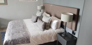 克尼斯纳Somervreug Guesthouse的一间卧室配有带枕头和台灯的床