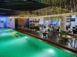 马卡萨KHAS Makassar Hotel的一个带桌椅的游泳池以及一间餐厅