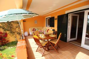 苏昂博Appartamento Marianda - Son Bou的庭院内桌椅和遮阳伞