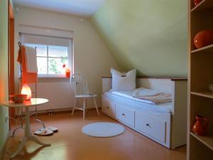 上阿斯巴赫欧克那玛思迪旅馆的一间小卧室,配有一张床和一把椅子
