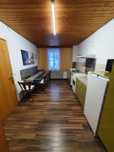 NordhalbenGästehaus Weißes Lamm - MONTEURZIMMER的厨房设有木制天花板和桌椅
