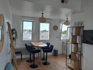 圣皮耶尔基贝龙Studio calme 20m² à 500 mètres de la plage/ centre的一间带桌椅和2扇窗户的用餐室