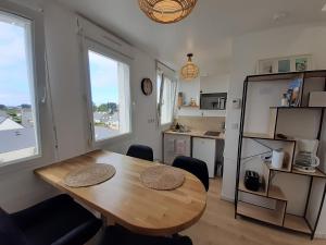 圣皮耶尔基贝龙Studio calme 20m² à 500 mètres de la plage/ centre的一间带桌子的用餐室和一间厨房