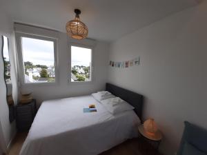 圣皮耶尔基贝龙Studio calme 20m² à 500 mètres de la plage/ centre的卧室配有白色的床和2扇窗户。