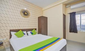 哥印拜陀Treebo Trend Everest Residency Tidel Park的一间卧室配有一张绿色的大白色床。