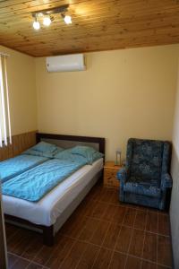 代姆延FŰZFA VENDÉGHÁZ的一间卧室配有一张床和一把椅子