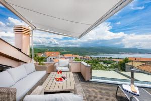 科尔尼奇Villa Antonia的阳台配有沙发和桌子。