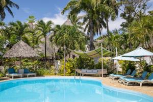 迪亚尼海滩Aestus Villas Resort的度假村的游泳池,配有椅子和遮阳伞