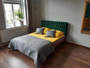 比得哥什Kamienica Bydgoska的一间卧室配有一张带绿色床头板的床