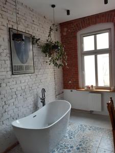 比得哥什Kamienica Bydgoska的砖墙客房内的白色浴缸