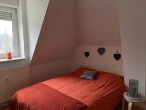 孔特雷克塞维尔COSY APPART NUMERO 2的一间卧室设有红色的床和窗户。