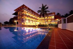 特里凡得琅Aadisaktthi Leisure Resort, Kovalam的大楼前设有游泳池的酒店