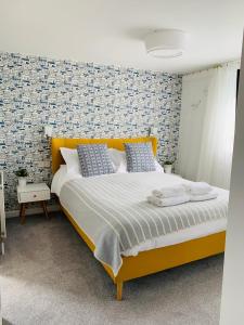 纽基Porth Beach Hotel的一间卧室配有一张带蓝色枕头的大型黄色床