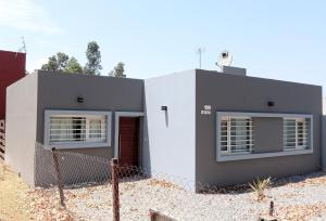内科切阿Casa Parque Playa的白色和黑色的房子,带围栏