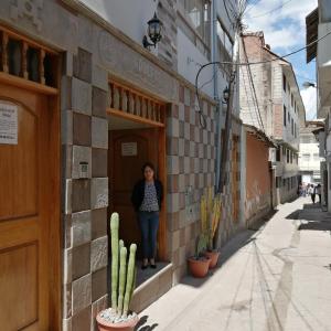 库斯科Dreams House Cusco的站在建筑物门口的女人