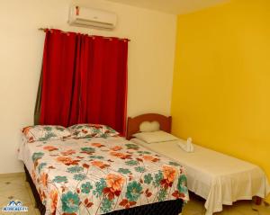 日若卡-迪热里科阿科阿拉Pousada aconcheg'us的一间卧室配有床和红色窗帘