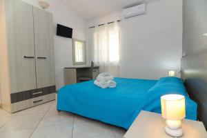 特罗佩阿B&B del Sole Tropea的一间卧室配有蓝色的床和毛巾