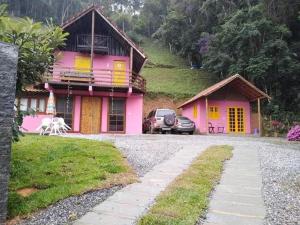 卢米亚Bangalô Boa Ventura的一座粉红色的房子,前面有一辆汽车