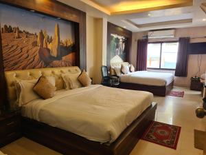 德拉敦Hotel Rajpur Heights的酒店客房设有两张床,墙上挂有绘画作品