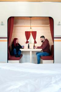 瓦尔·蒂利兹Peanut Mountain Lodge & Le Communal的两个人坐在一个房间里桌子上